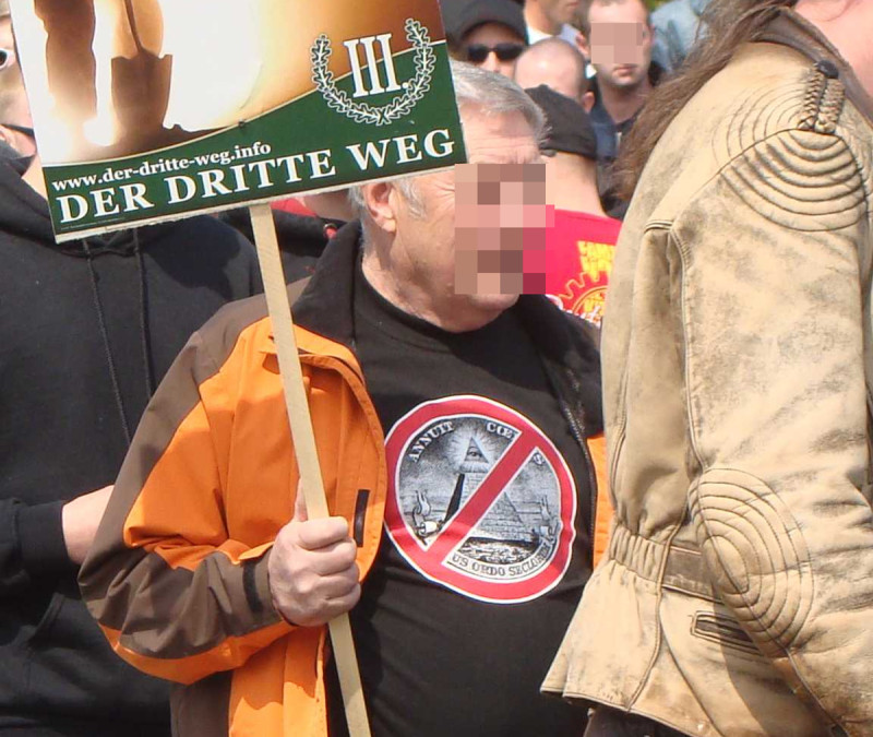 Die Shirt-Motive, die hier auf neonazistischen Aufmärschen gezeigt werden, bilden einen Ausschnitt der amerikanischen Ein-Dollar-Note ab.