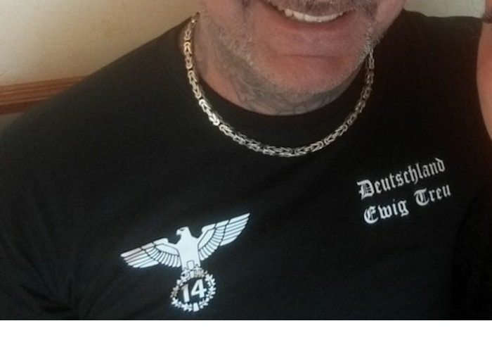 Ihre Zugehörigkeit zur extremen Rechten präsentiert die Bruderschaft Deutschland mitunter durch ein Symbol, das einen Reichsadler zeigt, der in seinen Krallen einen Blätterkranz mit der Zahl 14 hält. Ergänzt wird das Motiv durch die Parole »Deutschland Ewig Treu«.