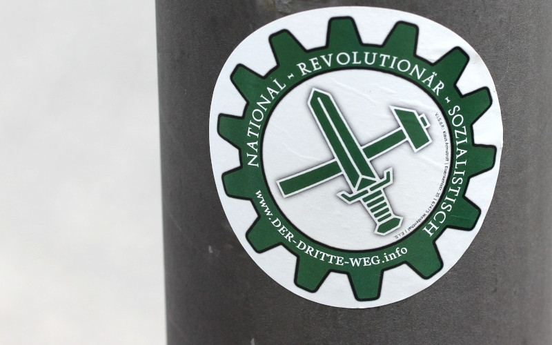 Das Zahnrad, in das Hammer und Schwert eingefasst sind, ist ein zweites Parteilogo der Partei Der III. Weg.