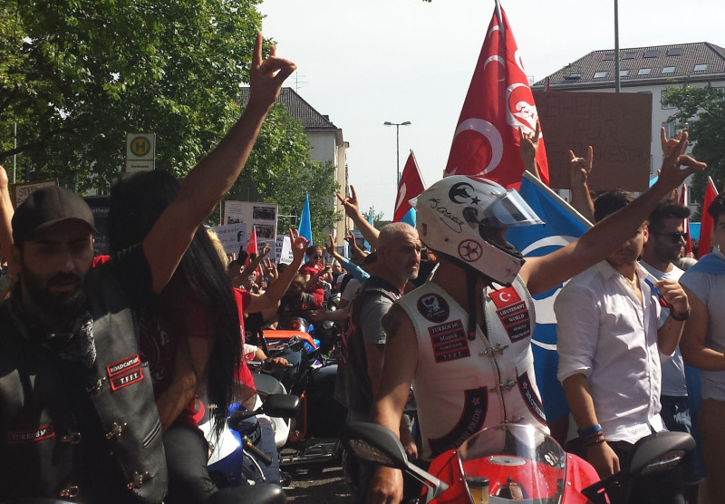 Der Rockerclub Turkos MC unterhält in Bayern mehrere Chapter. In ihm finden sich Anhänger der Grauen Wölfe wie auch Unterstützer der Hells Angels ein. Das Foto zeigt Personen in »Kutten« des Turkos MC, die bei einer Versammlung in München den »Wolfsgruß« entbieten.