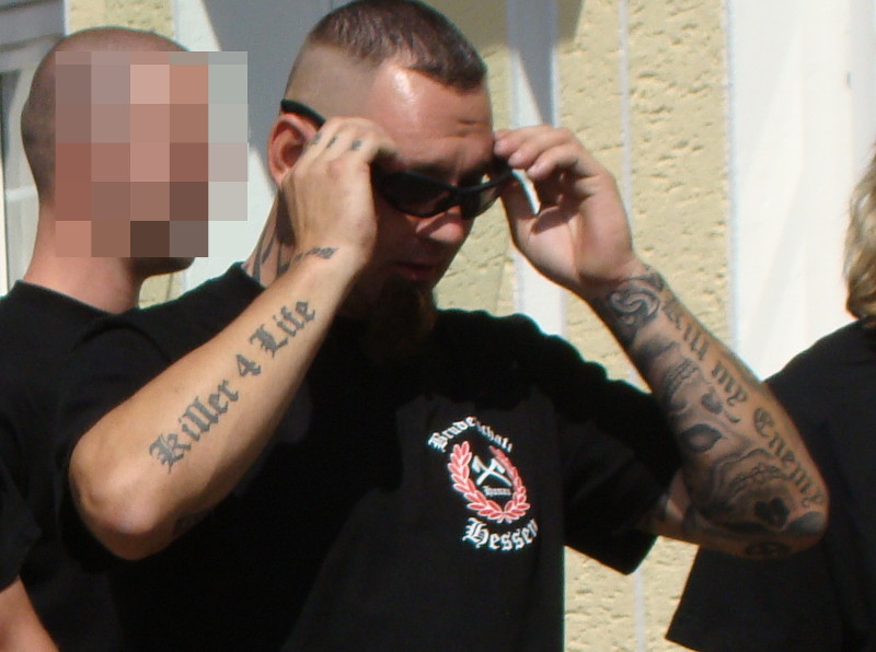 Führende Person der Neonazigruppe Bruderschaft Hessen auf einem Aufmarsch 2012. Auf seinen Unterarmen befinden sich die Tätowierungen »Killer 4 Life« und »Kill my Enemy«.