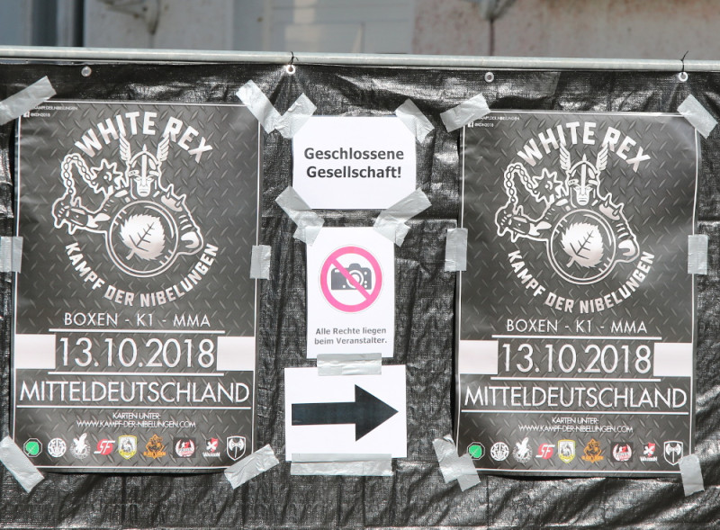 Eingangsbereich eines neonazistischen Kampfsport-Events am 13. Oktober 2018 in Sachsen. Eingeladen hatten »Kampf der Nibelungen« und »White Rex«. Weitere neonazistische Kampfsport-Labels traten als Unterstützerinnen auf. 2019 kam es - unter anderem im Streit um die Aufteilung der Gewinne - zum Bruch zwischen »Kampf der Nibelungen« und »White Rex«.
Zu den neonazistischen Kampfsport-Labels siehe auch: https://runtervondermatte.noblogs.org/marken-labels-vereine/
